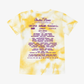 A kids’ yellow and white tie-dye t-shirt from EP 2026 Click & Collect, featuring the Electric Picnic 2026 festival lineup—including artists like Lewis Capaldi and CMAT—printed in purple text on the back.