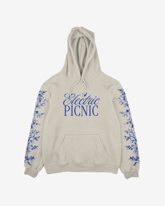The Cherub Harp Hoody by Electric Picnic is a light beige hoodie featuring large blue script Electric Picnic on the front and blue floral designs down both sleeves.