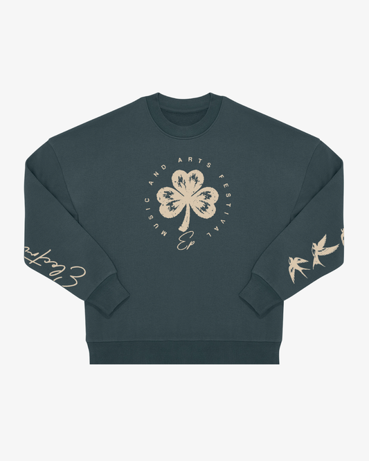 The EP 2026 Click & Collect "Click & Collect Vintage Clover Crewneck 2" features a dark green color with a cream four-leaf clover and "Music and Arts Festival" text on the front. Birds and cursive writing decorate the sleeves, all displayed against a plain white background.
