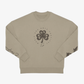 Introducing the EP 2026 Click & Collect Vintage Clover Crewneck Natural—a beige crewneck sweatshirt featuring a bold black four-leaf clover graphic and circular “Music and Arts Festival” text on the front, complemented by black printed designs on both sleeves.