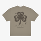 The Click & Collect Vintage Clover Oversized T-Shirt by EP 2026 Click & Collect features a beige design with a large distressed black four-leaf clover graphic, two small birds, and “Electric Picnic Music and Arts Festival” text on the back.
